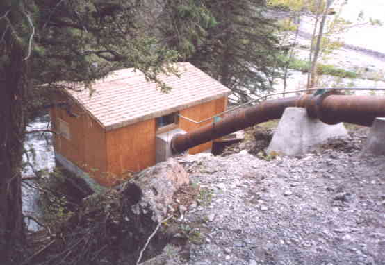 The penstock firmly anchored to concrete blocks descends to the power house.